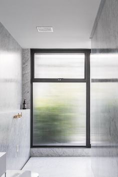 an empty bathroom with large windows and marble walls