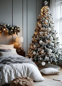 a bedroom decorated for christmas with white and silver decorations on the tree, bed linens and pillows