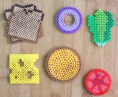 four pieces of perler bead sitting on top of a wooden table