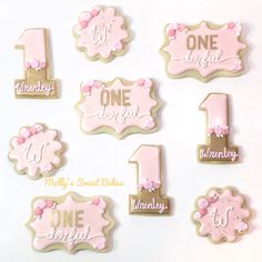 pink and gold first birthday cookies with the number one on them