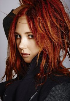 a woman with red hair is posing for the camera