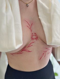 a woman's stomach with a tattoo on her belly and flowers drawn on it