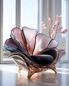 a glass sculpture sitting on top of a table next to a vase filled with flowers