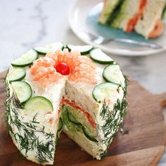 a cucumber and salmon cake on a cutting board with one slice cut out