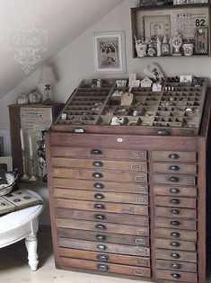 an old wooden filing cabinet with many drawers and pictures on the wall above it in a bedroom