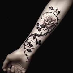 a black and white photo of a rose tattoo on the left arm, with leaves around it