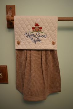 a towel hanging on the wall with a sign that says home sweet home