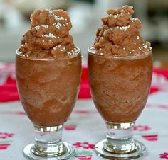 two glasses filled with ice cream on top of a table