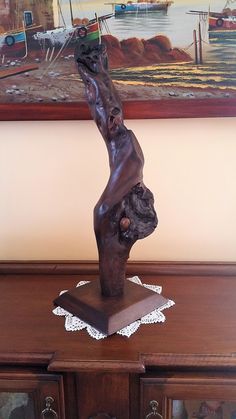 a bronze statue on top of a wooden dresser