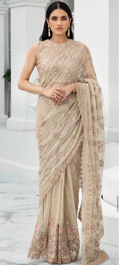 a woman in a beige sari