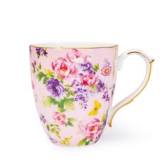 a pink coffee cup with flowers painted on the outside and gold trimming around the edge