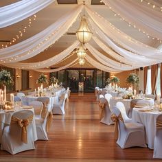 a banquet hall with tables and chairs covered in white draping, decorated with candles and flowers