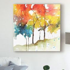 an abstract painting of three trees with colorful leaves on the tree tops and watercolor paint splatters all over them