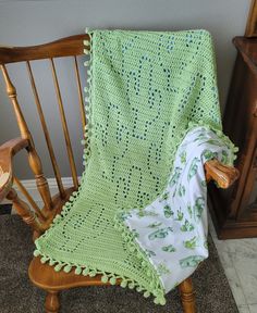 a green crocheted blanket sitting on top of a wooden rocking chair