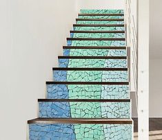 a set of stairs painted with blue and green tiles