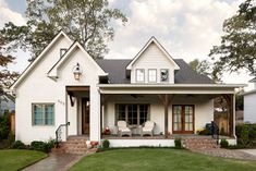 a white house sitting on top of a lush green field