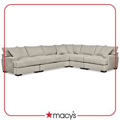 a large sectional couch with pillows on the top and bottom corner, in beige fabric