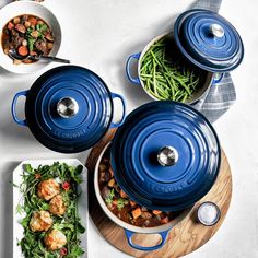 blue pots and pans filled with food on top of a table