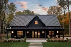 a black house with a metal roof in the evening