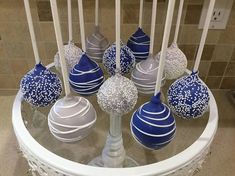 there are many blue and white candies on the glass table with candlesticks