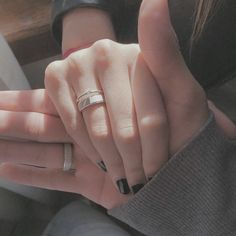 two people holding each other's hands with rings on their fingers