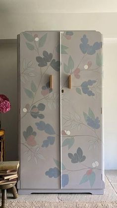 an old refrigerator is painted with flowers on it's side and has two doors