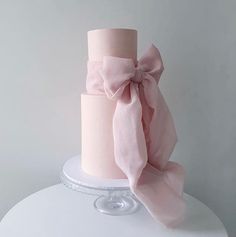 a pink cake with a bow on top