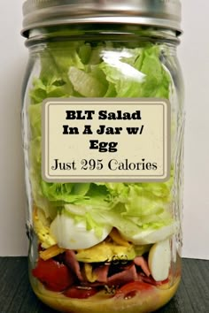 a jar filled with lettuce and other vegetables