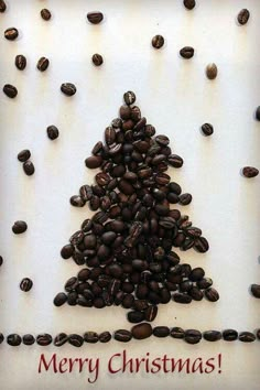 a christmas tree made out of coffee beans on top of a white board with merry christmas written in red