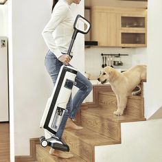 a woman is standing on the stairs with her luggage and a dog looking at her