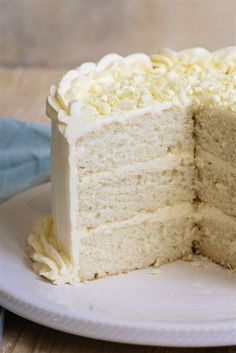 a white cake on a plate with one slice cut out