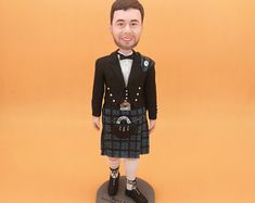 a caricature of a man in a kilt is standing on a base