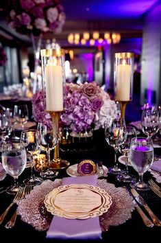 the table is set with candles, plates and napkins for an elegant wedding reception