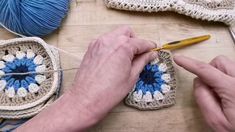 a person is crocheting on the floor with some balls of yarn next to them