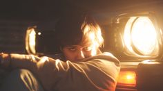 a young man sitting in the back of a car