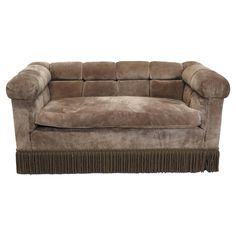 a brown couch with fringe trim on it