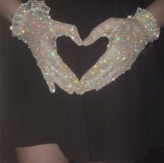 two hands in the shape of a heart made out of sequins on a black shirt