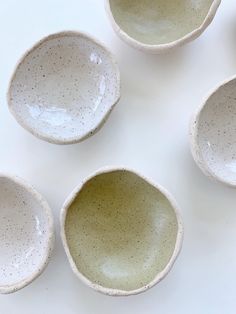 four white bowls with speckled designs on them