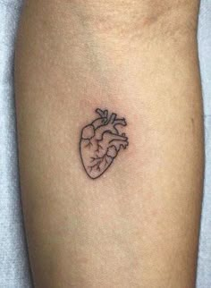 a small heart tattoo on the arm