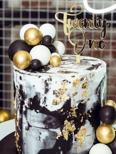 a black and white cake with gold decorations on it's top that says twenty one