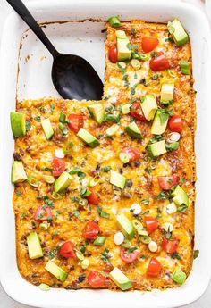 an enchilada casserole with tomatoes, avocado and other toppings