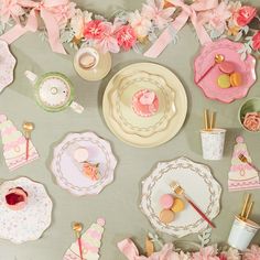 a table topped with lots of pink and white plates