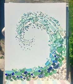 a painting made out of sea glass sitting on top of a table