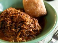 a green bowl filled with meat and bread