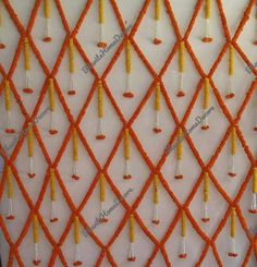 an orange and white wall hanging with beads