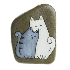 two cats sitting on top of a rock