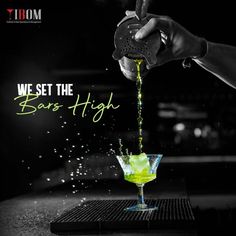 a person pouring green liquid into a martini glass with the words, we set the bar high