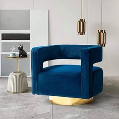 a blue chair sitting on top of a floor next to a table and lamp fixture