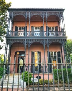 an old pink house with iron railings and balconies