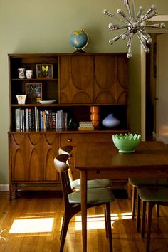 a dining room table and chairs in front of a bookshelf